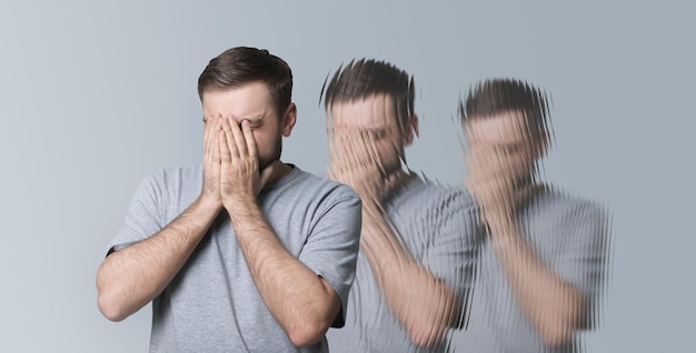 Scared man having hallucination on light grey background Distorted image