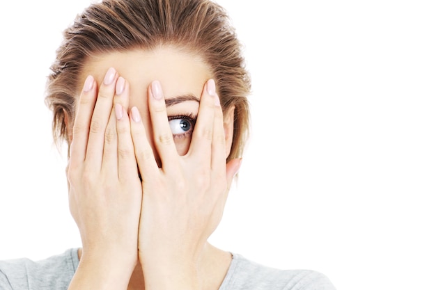 a scared woman covering her eyes over white background