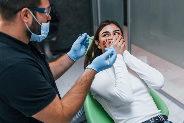 Scared woman have a visit in the dentist clinic. Conception of stomatology.