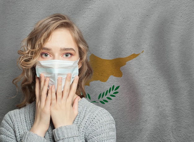 Фото Страшная женщина в медицинской маске на фоне кипрского флага эпидемия гриппа и домашнее насилие на кипре