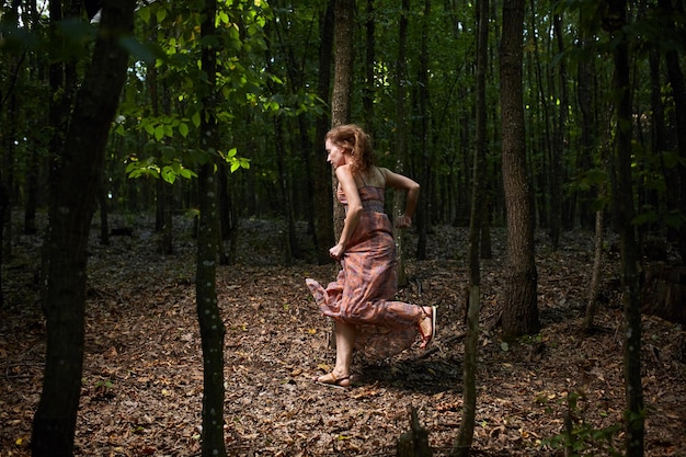 Scared woman running through the forest