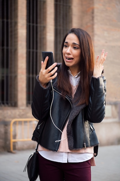 Donna spaventata che guarda il suo telefono