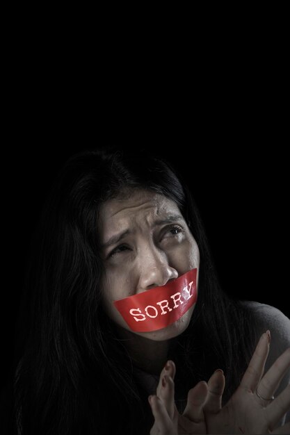 Scared woman with mouth covered by sorry word