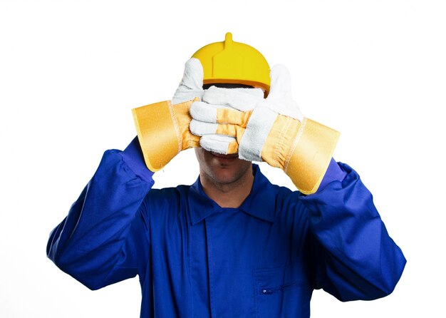 Scared worker covering his eyes on white background