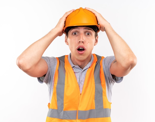 Scared young builder man in uniform grabbed head 