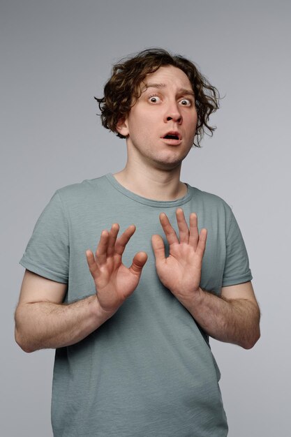 Scared young man studio portrait