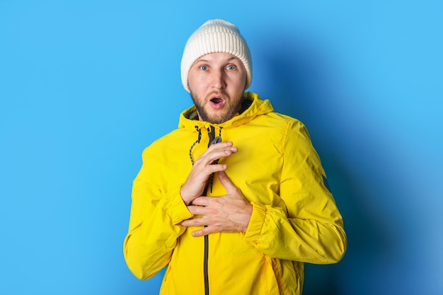 Scared young man in a yellow jacket on a blue background