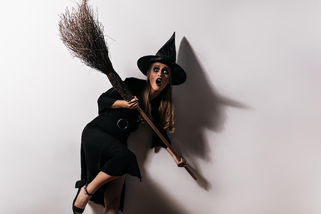 Foto giovane strega spaventata in posa dopo il carnevale foto in studio di un vampiro spaventato