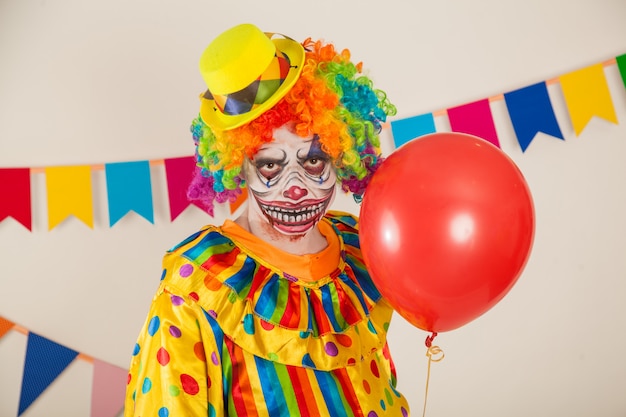 scary clown and red ball. Violence and childhood fear