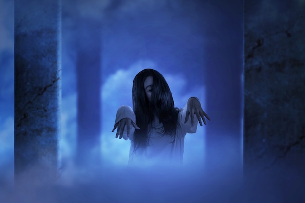 廃墟のビルに立っている怖い幽霊女。ハロウィーンのコンセプト