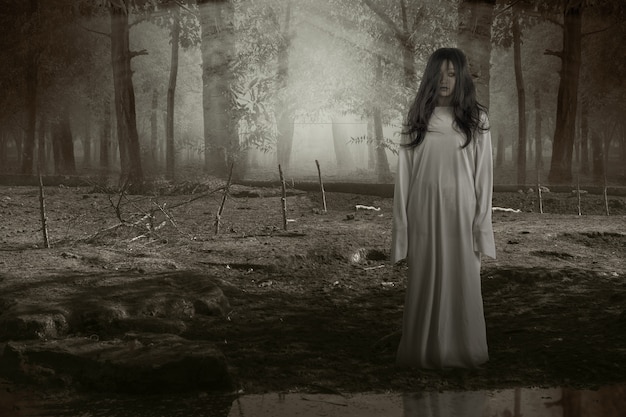 Scary ghost woman standing with haunted forest