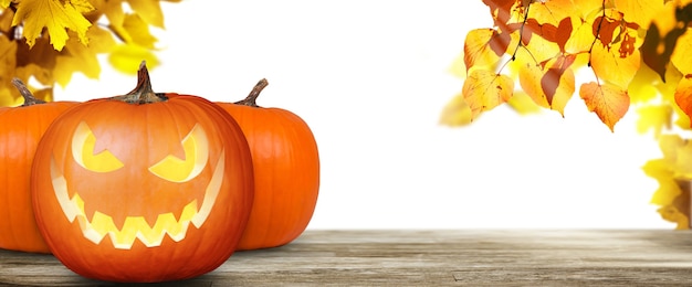 Scary Halloween pumpkin with eyes glowing inside on wooden background