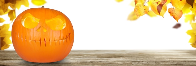 Scary Halloween pumpkin with eyes glowing inside on wooden background