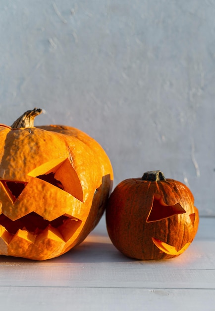 Scary Halloween pumpkins on a white wooden background at sunset Happy Halloween