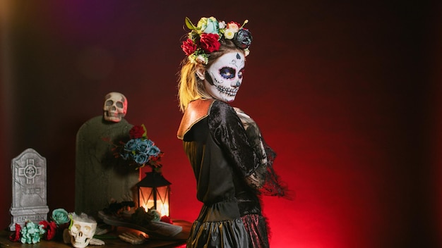 Scary horror woman trying to lure with hand, reach and tempt victims in studio. Flirty la cavalera catrina model with mexican festival costume on holiday celebration, day of the dead.