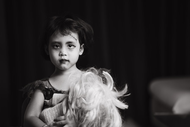 Scary looking small girl in halloween costume standing indoor