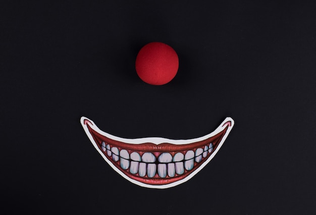 Photo scary red clown nose on black background