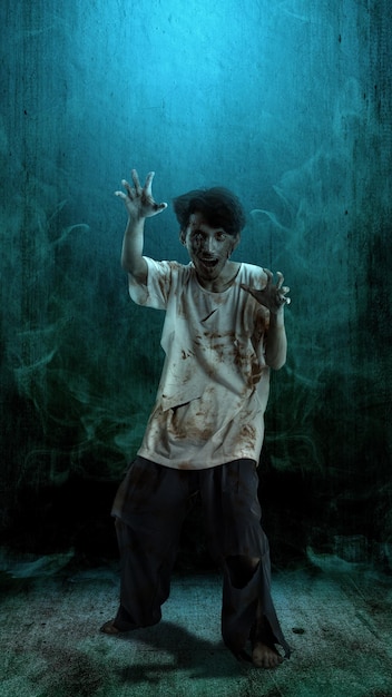 A scary zombie with blood and wounds on his body walking on a dark background Scary zombie Halloween concept