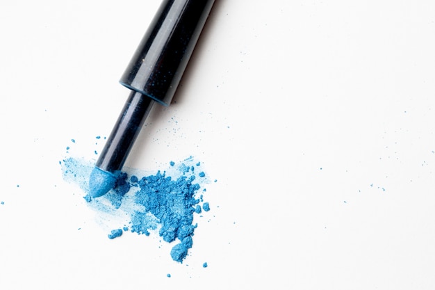 Scattered blue shadows with applicator on pure background