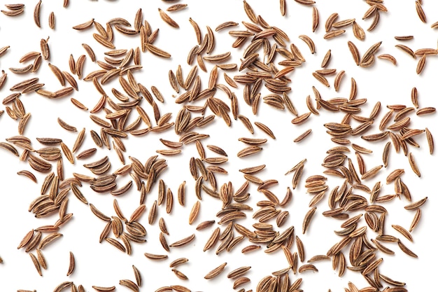 Scattered caraway seeds. Dried caraway seeds isolated on white background. Pile of cumin seeds. Seasoning for food cooking of worldwide kitchen. Top close up view.