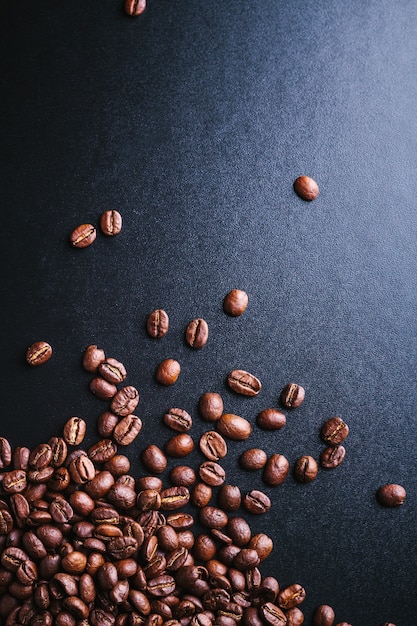 scattered coffee beans on a dark