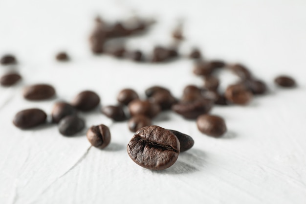 Photo scattered coffee beans on white, space for text