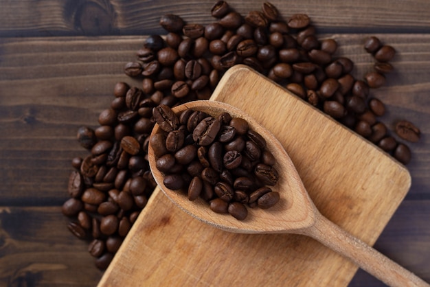 Scattered coffee beans on wooden table