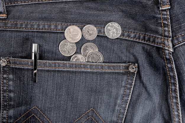 Scattered coins from pocket of jeans, denim