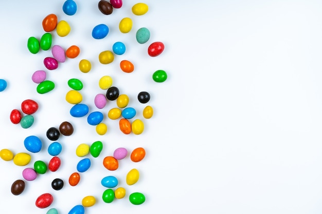 Scattered colored candy on white background. Bright round candies.