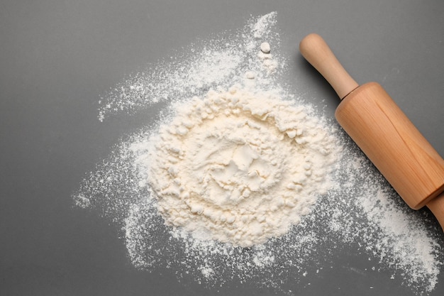 Scattered flour and rolling on gray background