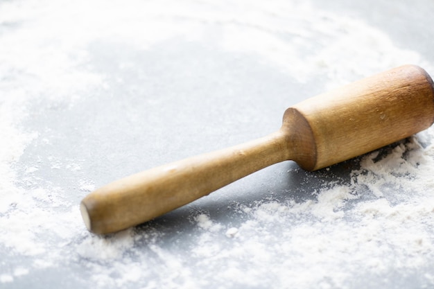 Scattered flour and rolling pin on grey table