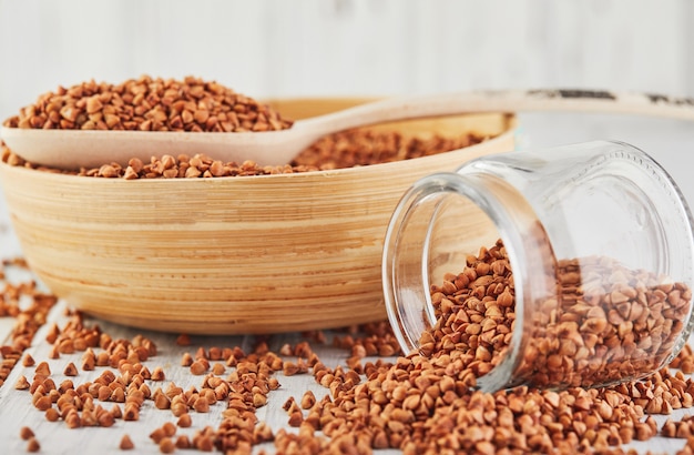 Scattered fresh dry buckwheat in a glass jar