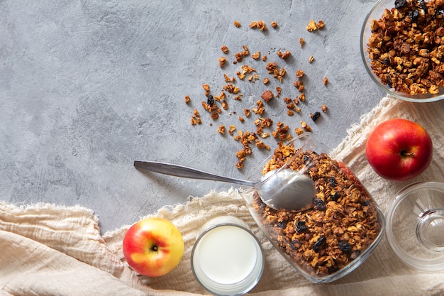 Foto muesli sparsi, latte, mele su un tavolo grigio