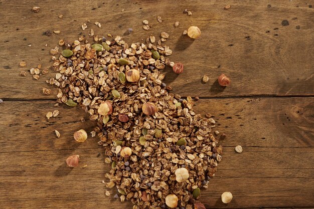 Scattered granola with dried fruits on a wooden table