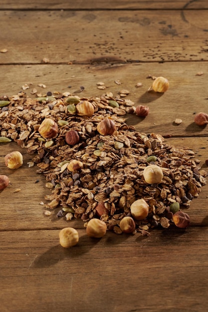 Scattered granola with dried fruits on a wooden table