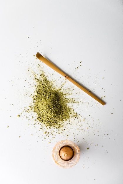 Photo scattered green matcha with bamboo cooking utensils