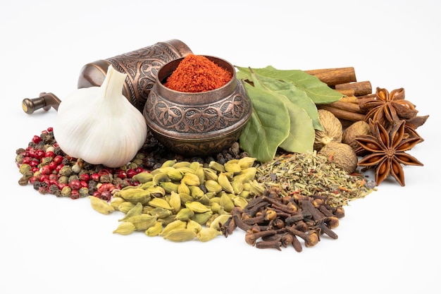 Scattered herbs and spices garlic anise and cinnamon spice mill\
isolated on white background