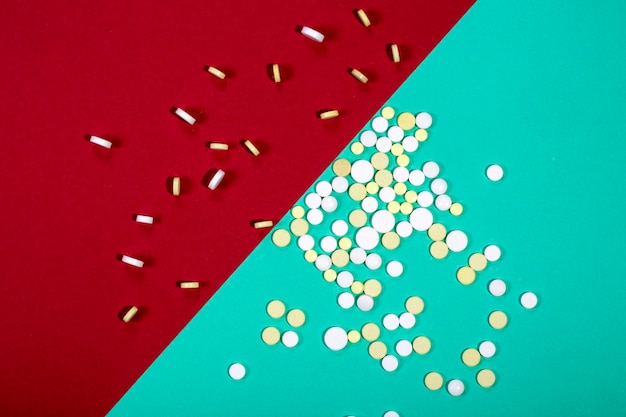 Scattered medical tablets on a colored background