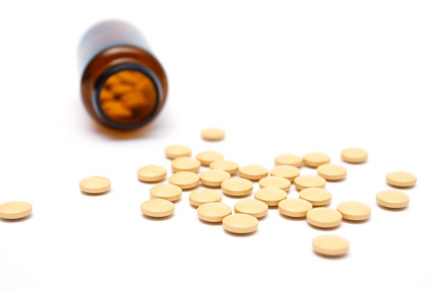 Scattered pills with glass bottle with small depth of field