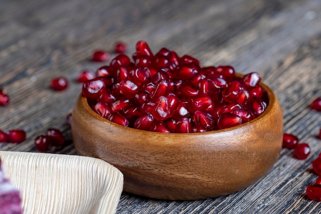 Scattered pomegranate seeds on a wooden board