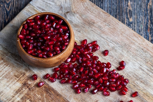 Scattered pomegranate seeds on a wooden board