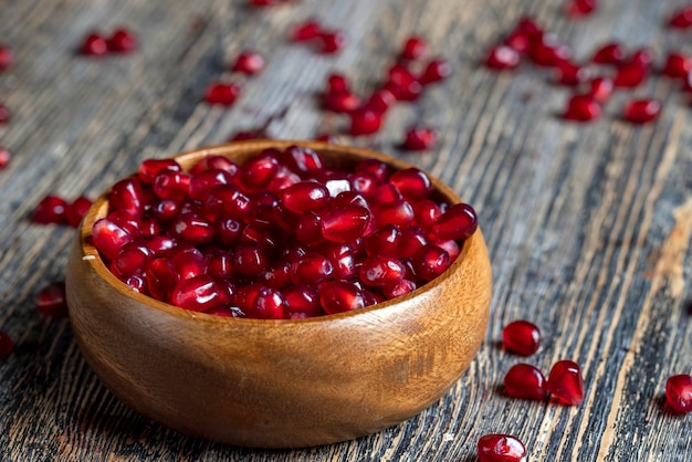 Scattered pomegranate seeds on a wooden board