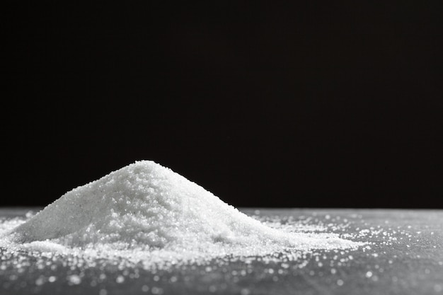 Scattered sugar on a black background close up