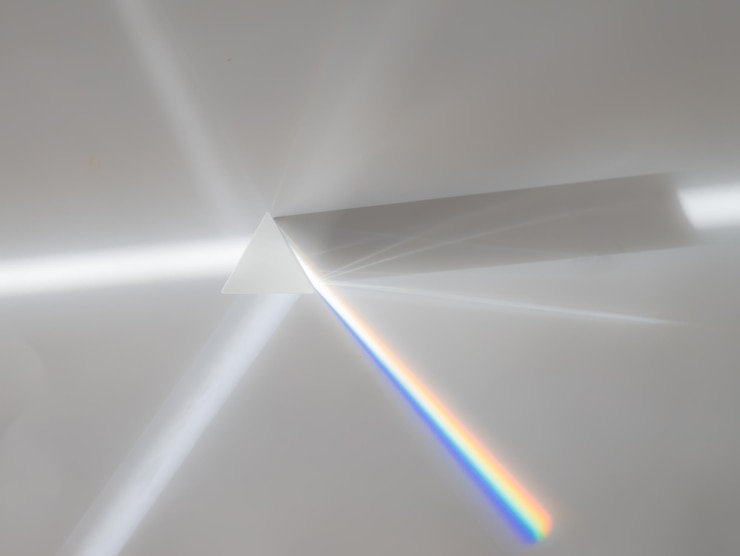 Photo scattering of a ray of sunlight (white light) through a prism creating refraction, reflection and decomposition of light in the colors of the rainbow