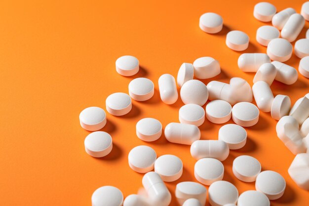 A Scattering of White Pills on an Orange Surface