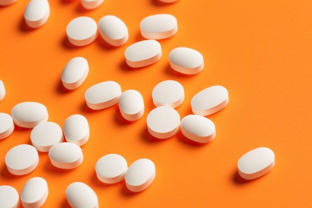 A Scattering of White Pills on an Orange Surface