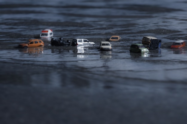 Scene of cars (miniature, toy model ) in flood from natural disasters,heavy rain, typhoon, hurricane.Transportation,Car insurance concept