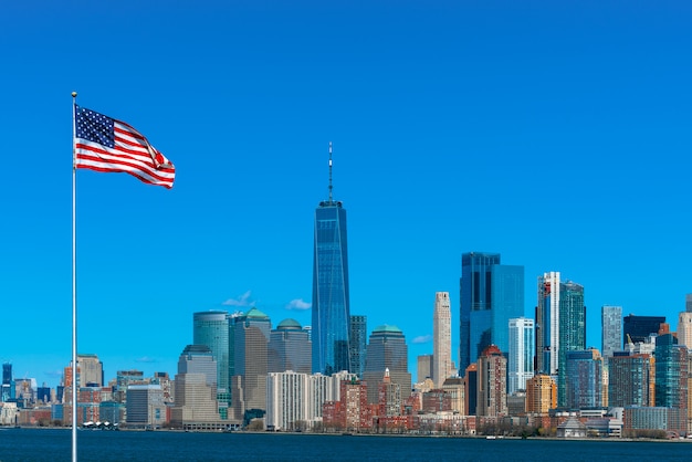 Scene of Flag of America over New york cityscape river side which location is lower manhattan,Architecture and building with tourist and Independence day 