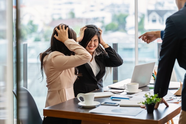 Scene of Furious boss scolding asian young couple businesswoman in formal suit by point to