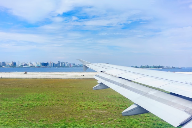 Scenery from airplane 's window after landing ,  seeing wing of airplane and MalÃ© , capital of  Republic of Maldives located in the Indian Ocean